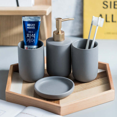 Solid color ceramic bathroom four-piece set, including a soap dispenser, toothbrush holder, tumbler, and soap dish. Sleek and modern design, made from durable ceramic to enhance the style and functionality of your bathroom